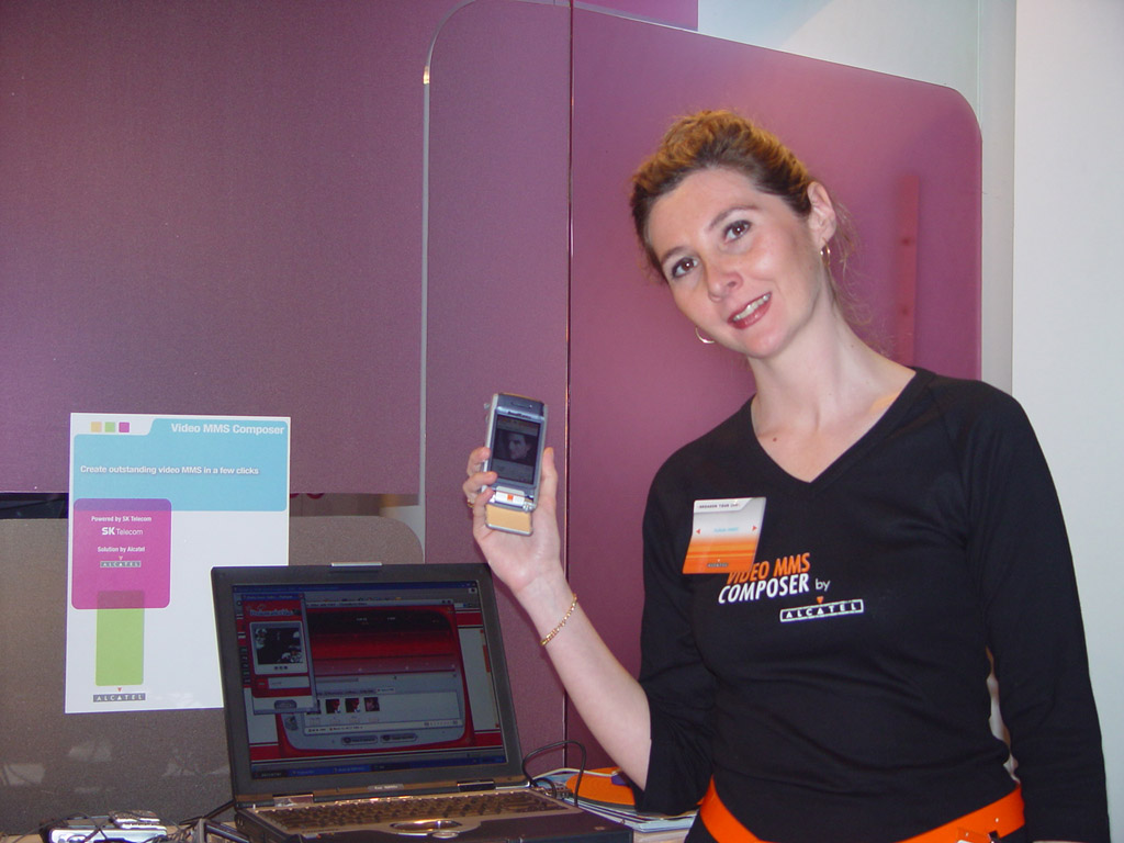 A person is shown using a PMV solution package service via a cellular phone. The service was developed jointly by SK Telecom and Alcatel, and introduced for the first time in the world to the 3GSM World Congress 2004, in Cannes of France